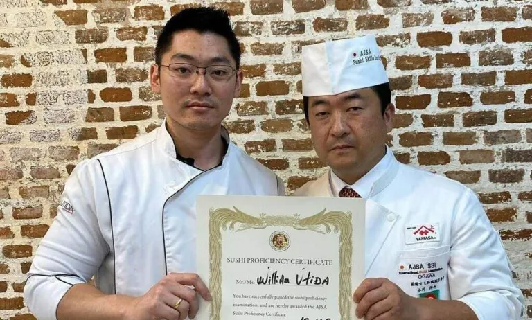 William Utida ao lado de Hirotoshi Ogawa, recebendo certificado de proficiência em sushi